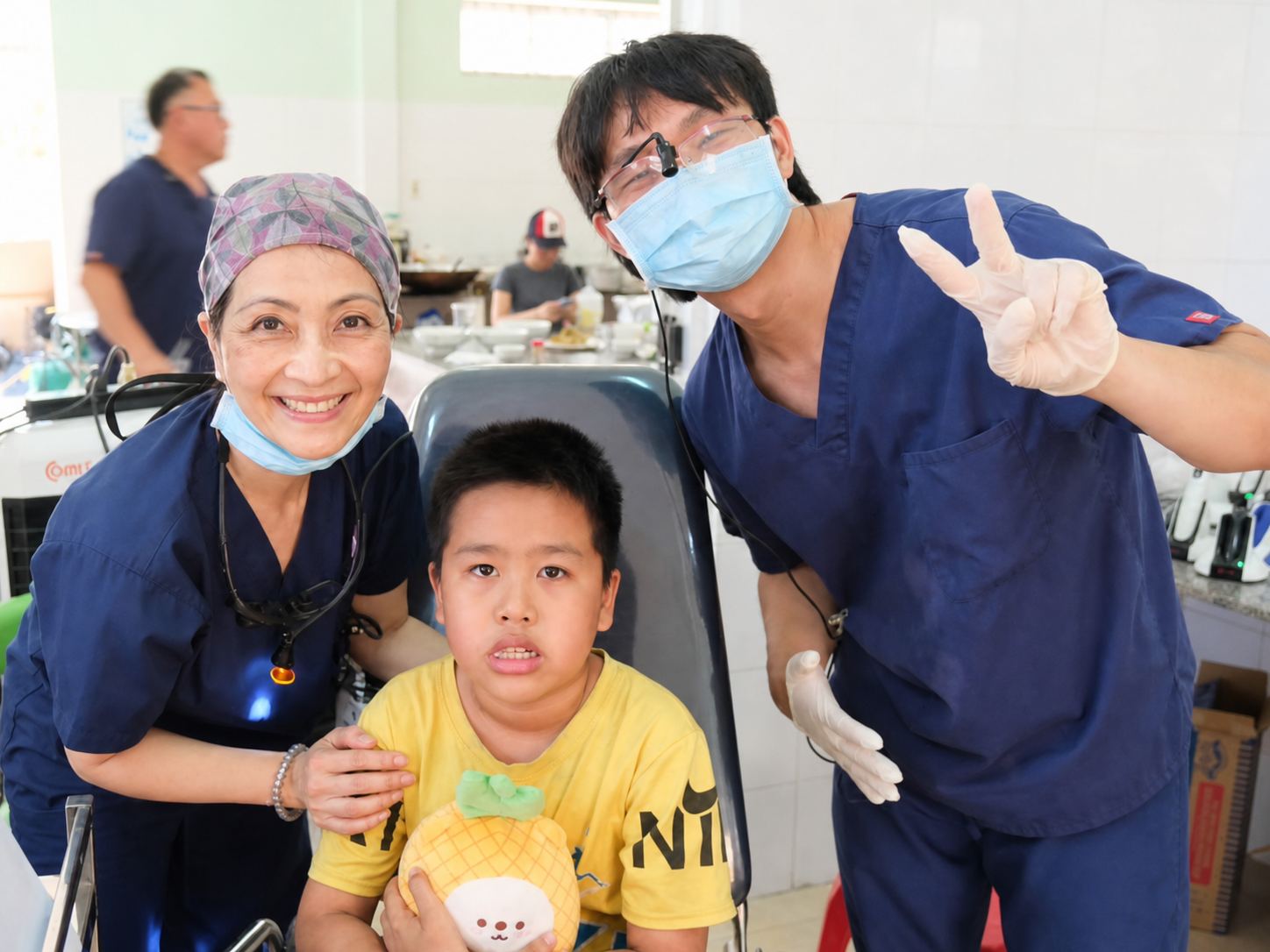 Luc Tran volunteering in a healthcare setting with a dentist and patient