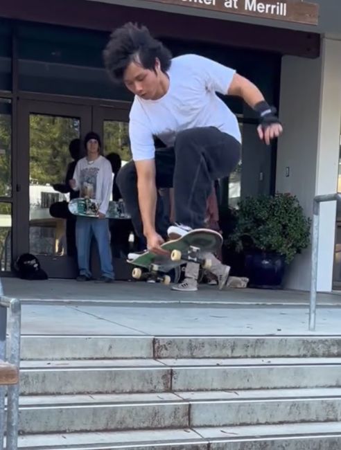 Luc Tran skateboarding on campus